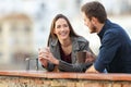 Couple or friends talking in a terrace drinking coffee