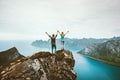 Couple friends traveling together on cliff edge in Norway