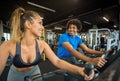 Couple of friends working out at the gym on a bike Royalty Free Stock Photo