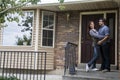 Couple in front of new home holding sold blackboard sign