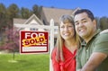 Couple in Front of Sold Real Estate Sign and House Royalty Free Stock Photo