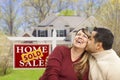 Couple in Front of Sold Real Estate Sign and House Royalty Free Stock Photo