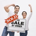 Couple with FSBO home sold sign. Royalty Free Stock Photo