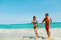 Couple Fun On Beach. Romantic People In Love Running At Sea Royalty Free Stock Photo