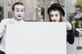Couple funny mimes holding sign