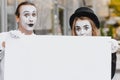 Couple funny mimes holding sign