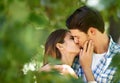 Couple, garden and kiss with love for date, bonding and romance with embrace in nature park. Man, woman and happy Royalty Free Stock Photo
