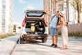 couple gathering for road trip. putting bags to car trunk Royalty Free Stock Photo