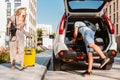 couple gathering for road trip. putting bags to car trunk Royalty Free Stock Photo