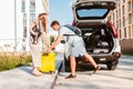 couple gathering for road trip. putting bags to car trunk Royalty Free Stock Photo