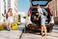 couple gathering for road trip. putting bags to car trunk Royalty Free Stock Photo