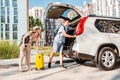 couple gathering for road trip. putting bags to car trunk Royalty Free Stock Photo