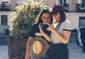 A couple of gay woman sightseeing together, smiling and looking his reflex photo camera. Same sex young married female couple