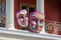 Couple of Giant Carnival Masks ?anging from the ?alcony of a Theater. Outdoor Decoration in Venetian Style.