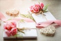 Couple of gift boxes wrapped with simple white craft paper and decorated with bouquet of roses and green bunch Royalty Free Stock Photo