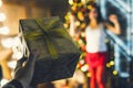 A man`s hand holds a gift box with bow and gives a joyful girl on Christmas eve. couple gift Royalty Free Stock Photo