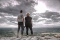 Couple, girl and boy, on hilly path. Both watch Royalty Free Stock Photo