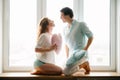 Couple girl and guy play with pillows near window. Royalty Free Stock Photo