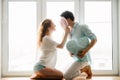 Couple girl and guy play with pillows near window. Royalty Free Stock Photo