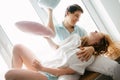 Couple girl and guy play with pillows near window. Royalty Free Stock Photo