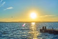 Couple of girls contemplate the sunset sitting on the dock of the Albufera in Valencia Royalty Free Stock Photo