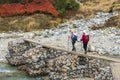 Couple Of Girls Are Hiking By Crossing The Bridge Over A Mountain River