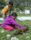 A couple of girls with a piglet outside the Otavalo animal market in Otavalo in Ecuador.