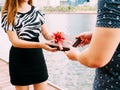 Couple giving a gift box to each other. Happy relationship in outdoor scene. Love and relationship concept Royalty Free Stock Photo