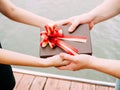 Couple giving a gift box to each other. Happy relationship in outdoor scene. Love and relationship concept Royalty Free Stock Photo