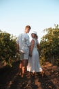 Smiling couple with glasses drinks wine in vineyaed