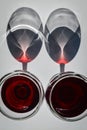 Couple of glasses of red wine with shadows and reflections on a white textured surface. Royalty Free Stock Photo