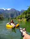 Couple going down Nam Song River in a tube surrounded by karst s