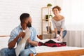 Woman Packing Suitcase And Man Studying Map Royalty Free Stock Photo