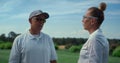 Couple golf players talk at grass course field. Golfers team chat on summer day. Royalty Free Stock Photo