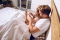 Couple of guy and girl lying in bed watching the cell phone Royalty Free Stock Photo