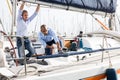 A couple of guys in blue shirts and jeans working on private sailing yacht in seaport