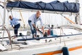 A couple of guys in blue shirts and jeans working on private sailing yacht in seaport