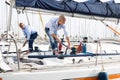 Couple of guys in blue shirts and jeans working on private sailing yacht in seaport