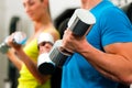 Couple in gym exercising with dumbbells Royalty Free Stock Photo