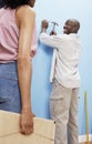 Couple Hammering Nail Into Wall