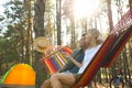 Couple resting in hammock outdoors on summer day