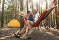 Couple resting in hammock outdoors on summer day