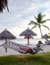 Couple in a hammock at Palm Beach Aruba Caribbean, white long sandy beach with palm trees Antilles Royalty Free Stock Photo