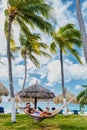 Couple in a hammock at Palm Beach Aruba Caribbean, white long sandy beach with palm trees Antilles Royalty Free Stock Photo