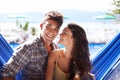 Couple, hammock relax at holiday resort for summer vacation in Hawaii for honeymoon, bonding or love. Man, woman and