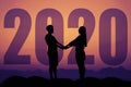 Couple hand in hand silhouette with big new year 2020 and sunset