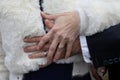 couple hand wedding rings on bride and groom fingers hands on marriage white wool jacket winter dress background Royalty Free Stock Photo
