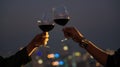 The Couple hand with wine glasses have a romantic dinner on the rooftop with sunset in a cityscape background Royalty Free Stock Photo