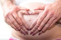 Couple with hands in a heart shape on pregnant belly Royalty Free Stock Photo