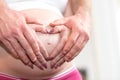 Couple with hands in a heart shape on pregnant belly Royalty Free Stock Photo